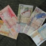 Varie banconote non valide per i pagamenti su sfondo bianco.