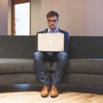 Giovane professionista lavora da remoto con laptop, simbolo di opportunità nel lavoro flessibile.